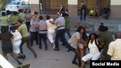 Damas de Blanco son arrestadas en su sede nacional en Lawton, La Habana. Al extremo derecho varias mujeres uniformadas cargan con Berta Soler, vocera del grupo femenino.