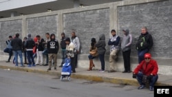 Un grupo de ciudadanos cubanos espera en la línea fronteriza de Nuevo Laredo (México) con territorio estadounidense este lunes 30 de enero de 2017. Decenas de cubanos se reúnen todos los días frente al Puente Internacional Las Américas de la fronteriza ci