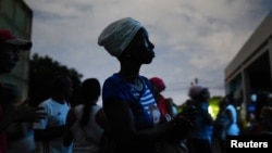 Una mujer espera recibir una ración mensual de pollo, durante un apagón, en un pequeño mercado estatal en Santiago de Cuba, el 20 de marzo de 2024. (REUTERS/Alexandre Meneghini)