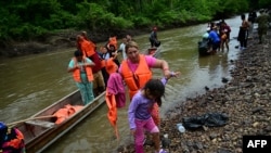 Migrantes descienden del barco a su llegada al Centro de Recepción Temporal para Migrantes en Lajas Blancas, en la selvática provincia de Darién