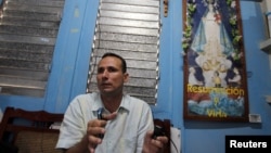 José Daniel Ferrer junto a una imagen de la Virgen de la Caridad del Cobre. (Reuters/Archivo)