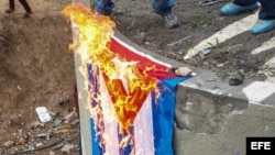 Un manifestante opositor quema una bandera de Cuba en una marcha contra la elección de la Asamblea Nacional Constituyente en Caracas.