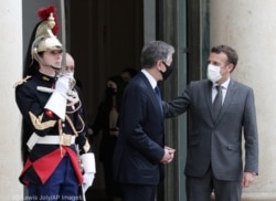 El secretario de Estado de Estados Unidos Antony Blinken (centro) y el presidente francés Emmanuel Macron hablando tras una reunión el 25 de junio en París. (© Lewis Joly/AP Images)