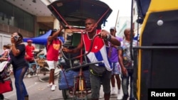 Un hombre empuja un bicitaxi cargado con mercancías en un mercado callejero en La Habana, el 19 de agosto de 2023. REUTERS/Alexandre Meneghini.