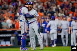 José Leclerc y Jonah Heim, de los Rangers de Texas, celebran la victoria contra los Astros de Houston (AP Foto/David J. Phillip)