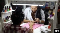 Una manicurista atendiendo a una clienta en un local rentado al estado