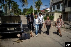 Los candidatos Denisse Ricardo, centro izq. y Carlos Miguel Pérez, centro, hacen campaña en La Habana, Cuba, el martes 21 de marzo de 2023. Se espera que unos ocho millones de cubanos voten el domingo 26 de marzo por los diputados que integrarán la Asamblea Nacional del Poder Popular. (Foto AP/Ramón Espinosa)