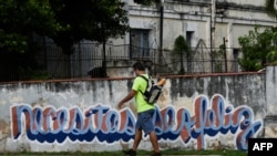 Un hombre pasa junto al grafiti del artista cubano Mr. Sad en La Habana, el 18 de diciembre de 2024.