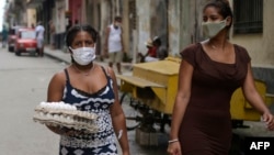 Mujeres cargan alimentos en una calle de a Habana. (Yamil LAGE / AFP)