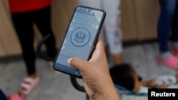 Un inmigrante solicita una cita de asilo por medio de la app CBP ONE en Reynosa, México. REUTERS/Daniel Becerril