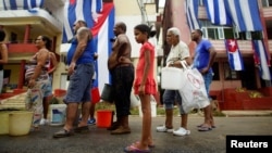 Personas esperan en una fila para buscar agua. REUTERS/Alexandre Meneghini