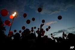 Manifestantes sueltan globos mientras piden la liberación de la familia Bibas, cuyos miembros permanecen secuestrados en la Franja de Gaza por el grupo militante Hamás, en Tel Aviv, martes 28 de noviembre de 2023. (AP Photo/Ariel Schalit)