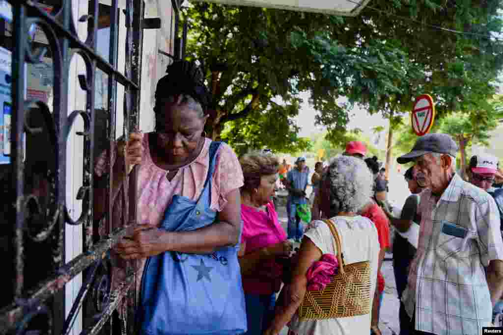 Una mujer se aferra a una valla a la salida de una tienda en La Habana. Cuba es un país que envejece en medio de una crisis demográfica acelerada por la migración masiva. REUTERS/Norlys Pérez