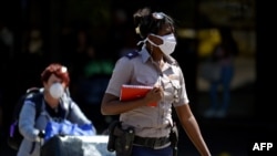 Una agente de la policía una pasajera en el Aeropuerto Internacional José Martí de La Habana, el 13 de marzo del 2020.