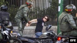 Miembros de la Guardia Nacional Bolivariana detienen a manifestantes.