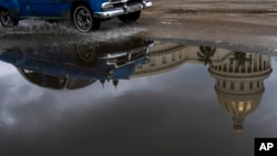 El reflejo del Capitolio, sede del Parlamento cubano, en un charco de agua, en medio del colapso energético que vivió el país la semana pasada. (AP/Ramón Espinosa)