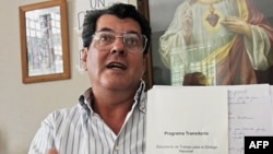 Oswaldo Payá muestra el documento temporal de un programa tentativo para un diálogo nacional durante una conferencia de prensa en su casa, en La Habana, el 17 de febrero de 2005.