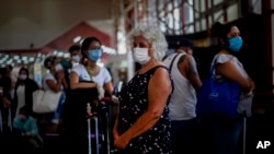 Viajeros usan maáscaras protectoras contra el coronavirus en el Aeropuerto Internacional José Martí de La Habana.