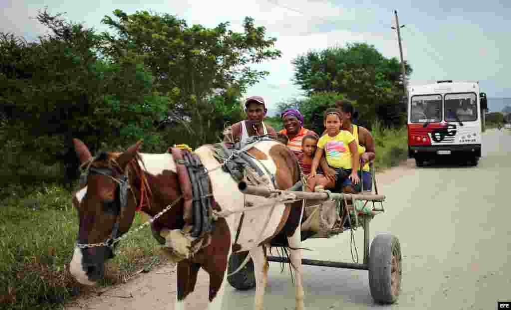 Una familia se dirige con sus pertenencias a un lugar seguro hoy, lunes 03 de octubre de 2016, en la ciudad de Guantánamo (Cuba), ante la proximidad del huracán Matthew. Seis provincias de Cuba se encuentran bajo "alarma ciclónica" a la espera del potenci