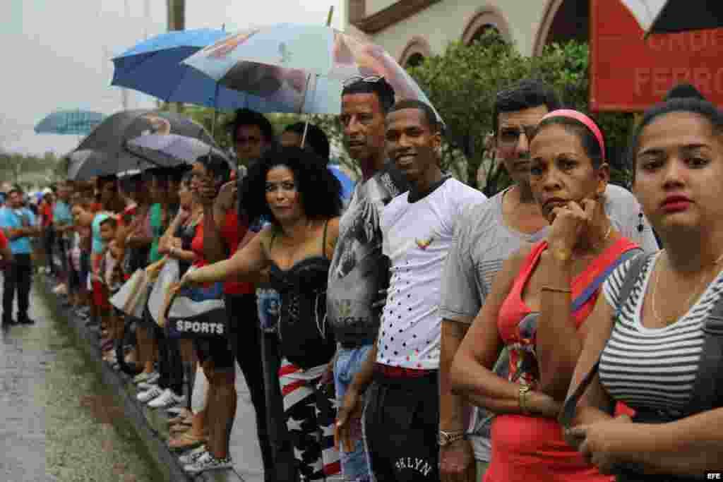  Un grupo de cubanos observa la llegada del presidente de los EEUU Barack Obama a Cuba a través de la señal de televisión captada por un teléfono móvil 