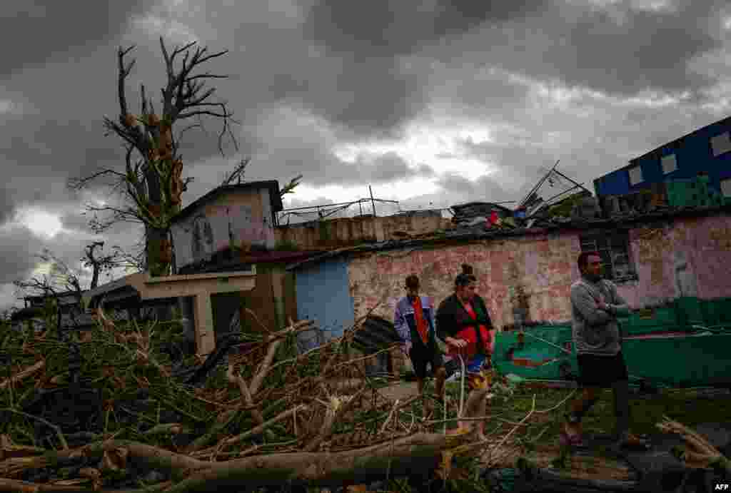 Residentes del barrio de Regla caminan sobre los escombros en busca de sus pertenencias. 