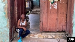 Un hombre descansa en la entrada de su casa en Santiago de Cuba, en septiembre de 2023. (Photo by Yamil LAGE / AFP)