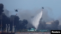 Helicópteros tratando de aplacar el incendio en la base de supertanqueros de Matanzas.