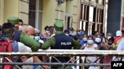 Cubanos se aglomeran en un mercado de La Habana, bajo la vigilancia de agentes de la policía, para comprar alimentos, el 12 de abril del 2020.