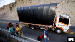 Migrantes venezolanos en una carretera.