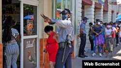 La policía organiza la cola en una TRD de Guantánamo. (Captura de foto/Venceremos)