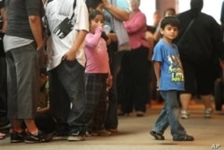 Niños hacen fila con algunos de los miles de jóvenes inmigrantes en el Navy Pier de Chicago. Foto: AP/Sitthixay Ditthavong.