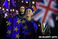 Anti-Brexit activists demonstrate with other protesters outside of the Houses of Parliament in central London on January 15, 2019. -