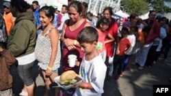 Migrantes centroamericanos que forman parte de la caravana reciben ayuda en un refugio en una localidad fronteriza de México.