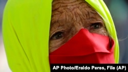 Una mujer participa en una protesta por el manejo gubernamental del COVID-19 en Brasilia, Brasil. AP Photo/Eraldo Peres