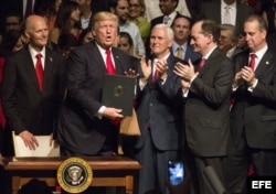 El presidente estadounidense, Donald J. Trump, muestra el memorando presidencial sobre la política con Cuba al finalizar su discurso en el teatro Manuel Artime de la Pequeña Habana.