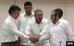 Raúl Castro abraza a Juan Manuel Santos y al líder de las FARC, Rodrigo Londoño, alias "Timochenko", tras la firma del acuerdo.