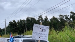 Carteles con mensajes en contra de la dictadura cubana en la caravana anticomunista