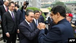 El presidente venezolano Nicolás Maduro (D) y el ministro chino de Exteriores Wang Yi se saludan, en Pekín el 14 de septiembre de 2018, en una imagen transmitida por la presidencia venezolana© Venezuelan Presidency/AFP MARCELO GARCIA