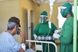 Personal médico atiende a un anciano presuntamente en la Escuela Especial Marta Abreu de Santa Clara, nuevo centro de aislamiento en la provincia de Villa Clara (Foto: Ernesto Álvarez Alonso/Emisora CMHW).