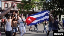 Manifestantes sostienen una bandera cubana durante las protestas del 11 de julio, en La Habana, Cuba. (REUTERS/Alexandre Meneghini/Archivo)