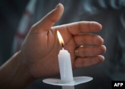 Una mujer sostiene una vela durante una vigilia por las víctimas del tiroteo en un WalMart de El Paso, Texas.