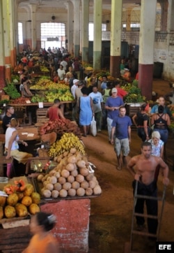 ARCHIVO. Trabajadores en un mercado ofertan sus productos.