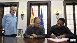 Javier Sotomayor firma hoy, viernes 25 de septiembre de 2015, la concesión de la nacionalidad española, en un acto encabezado por el cónsul general de España en Cuba, Jorge Montenegro y el embajador de España en la isla, Francisco Montalbán (d-i).