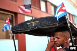 El conductor de un bicitaxi espera la llegada de clientes en una calle de La Habana.