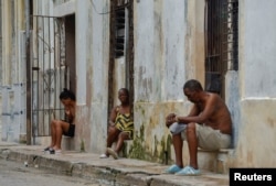 Las personas se sientan afuera de sus casas, luego de que los medios estatales informaron el sábado que la red nacional había colapsado por segunda vez en 24 horas, en La Habana, Cuba, el 19 de octubre de 2024. REUTERS/Norlys Perez