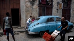 Niños juegan encima de un viejo auto clásico estadounidense en La Habana, Cuba, el sábado 9 de julio de 2022. (Foto AP/Ramon Espinosa).