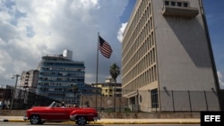 Un auto clásico pasa en frente de la embajada estadounidense en La Habana.