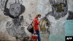 Una mujer usa una máscara protectora contra el coronavirus en una calle de La Habana. (YAMIL LAGE / AFP)