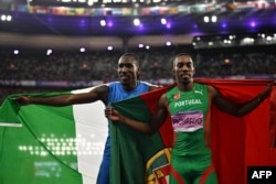 El medallista de plata Pedro Pichardo (derecha), compitiendo por Portugal, y el medallista de bronce, Andy Díaz Hernández, por Italia, celebran después de la final de triple salto masculino en los Juegos Olímpicos de París 2024. (Ben STANSALL / AFP)