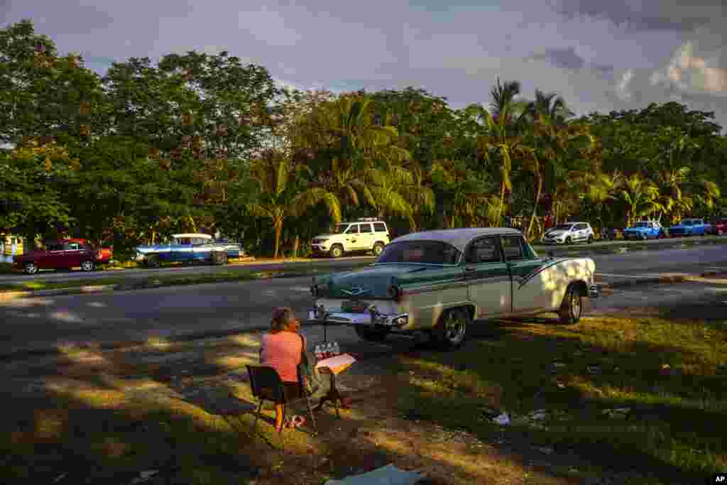 Un vendedor ambulante de jugos observa la fila de autos mientras los conductores esperan que llegue un camión cisterna con combustible, en La Habana, Cuba, el viernes 14 de abril de 2023. (Foto AP/Ramon Espinosa)